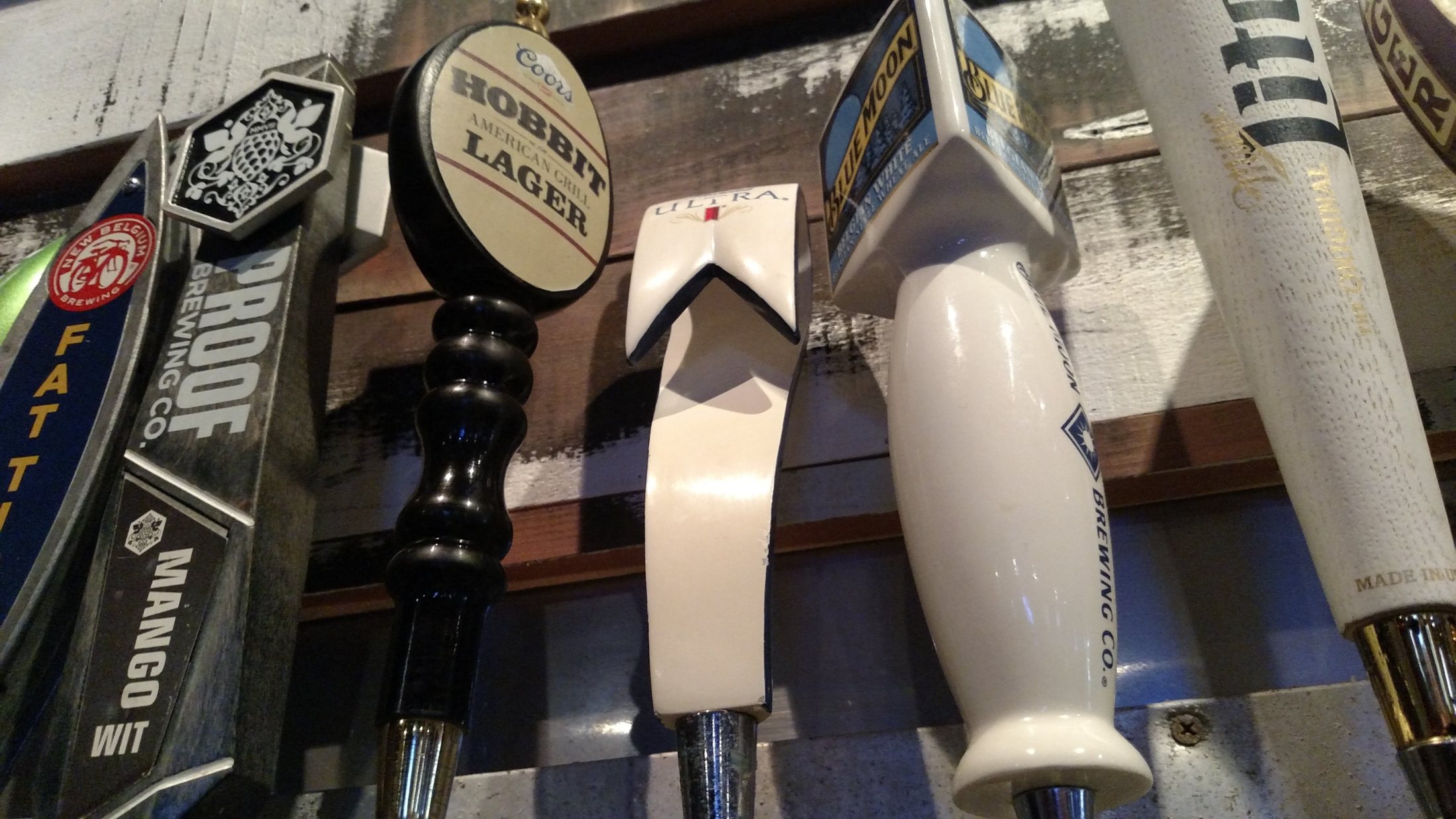 A row of draught beer tap handles along the bar.